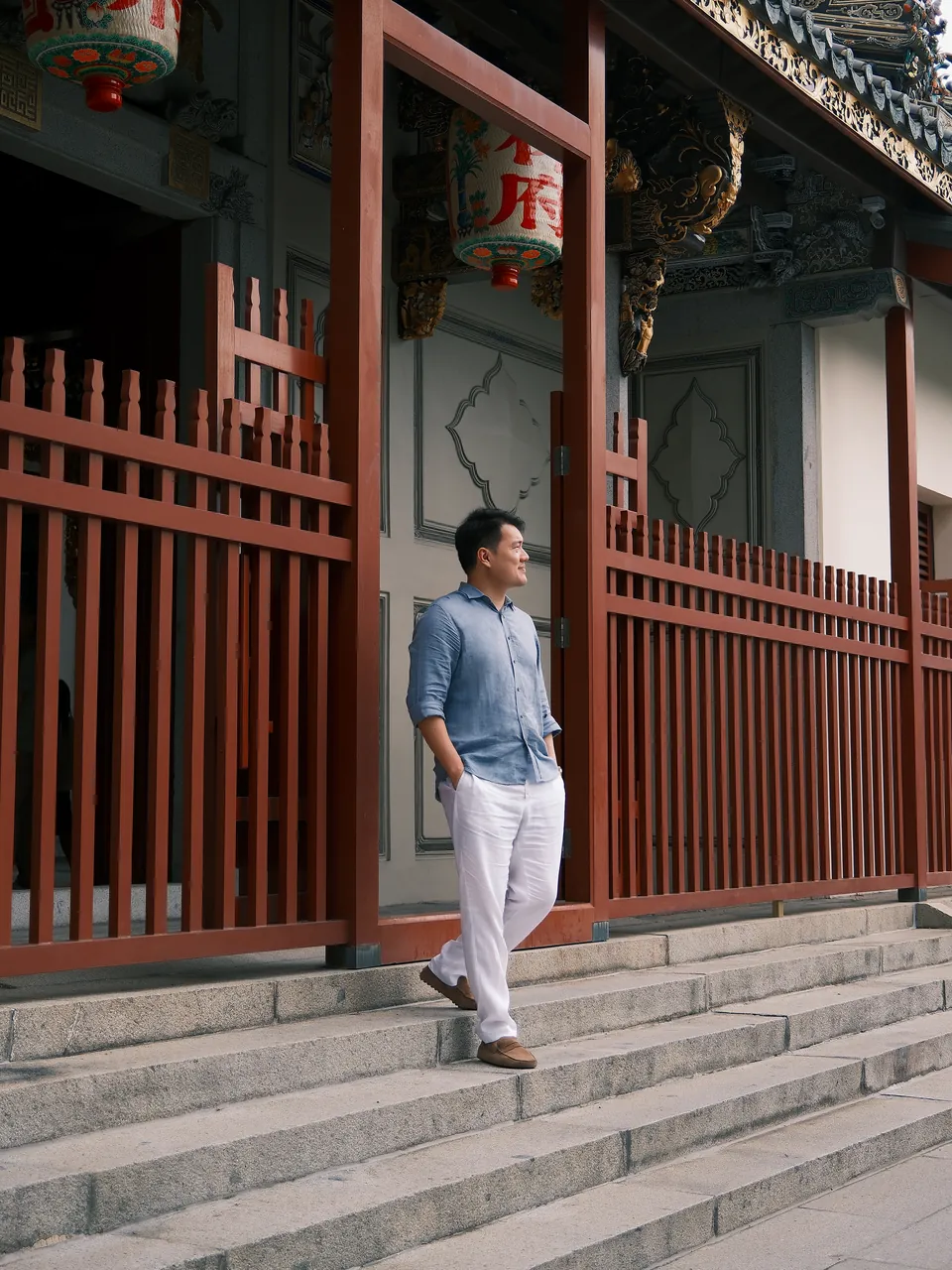 Sean Chan walking down the stone steps of a Chinese temple, past red timber railings and lanterns